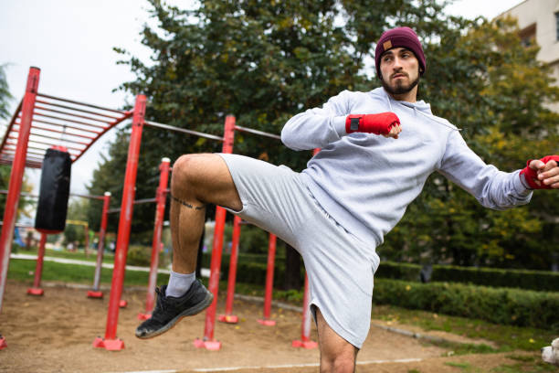 entraînement extérieur de kickboxing - men sweat combative sport boxing photos et images de collection