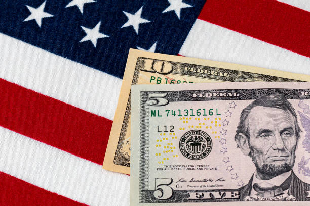 close-up de notas de 10 e 5 dólares com bandeira americana.  conceito de aumento do salário mínimo federal de 15 dólares. - minimum wage - fotografias e filmes do acervo
