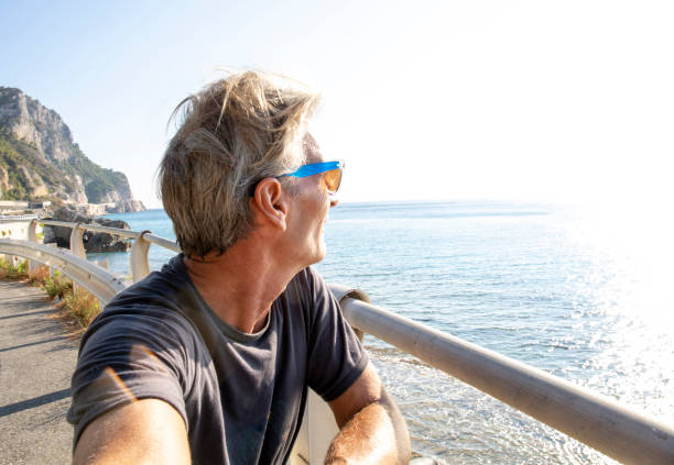 istock Man pauses with bicycle on promenade over the sea 1298410896