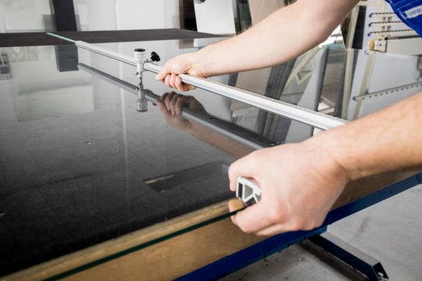 istock The glazier cuts the glass with a cutting sledge on a professional table in the workplace 1298411905
