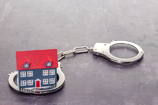 Small house caught in handcuffs - real estate fraud