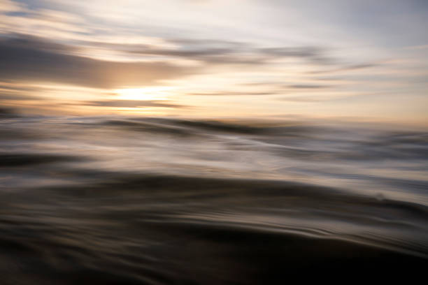 istock Sun rising over the ocean with motion blurred golden water surface 1298415340