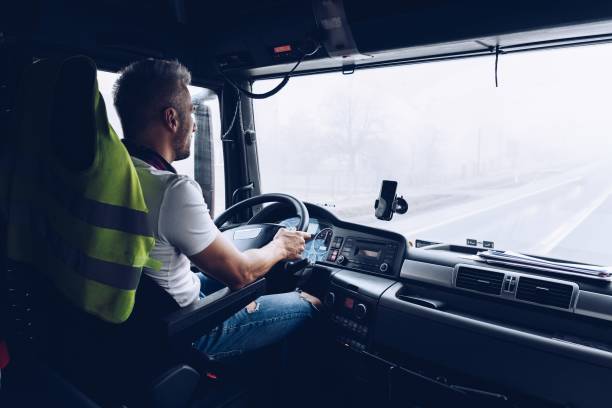 Handsome driver at the wheel of a truck at work. stock photo