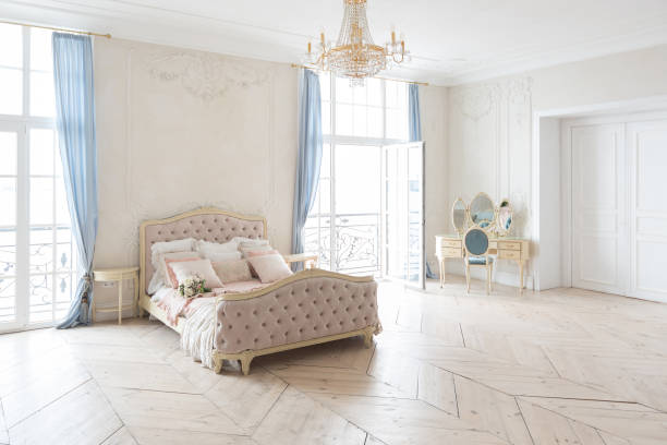 istock luxurious light interior in the Baroque style. A spacious room with a road chic beautiful furniture, a fireplace and flowers. plant stucco on the walls and light wood parquet 1298424518