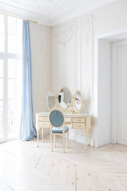 istock luxurious light interior in the Baroque style. A spacious room with a road chic beautiful furniture, a fireplace and flowers. plant stucco on the walls and light wood parquet 1298424531