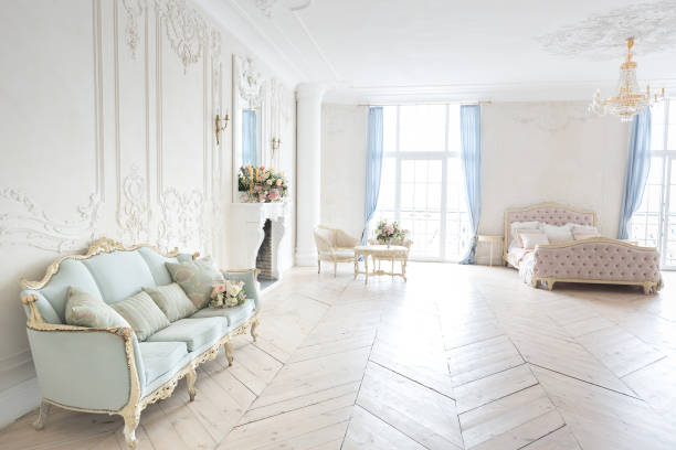 istock luxurious light interior in the Baroque style. A spacious room with a road chic beautiful furniture, a fireplace and flowers. plant stucco on the walls and light wood parquet 1298424536