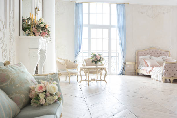 istock luxurious light interior in the Baroque style. A spacious room with a road chic beautiful furniture, a fireplace and flowers. plant stucco on the walls and light wood parquet 1298424537