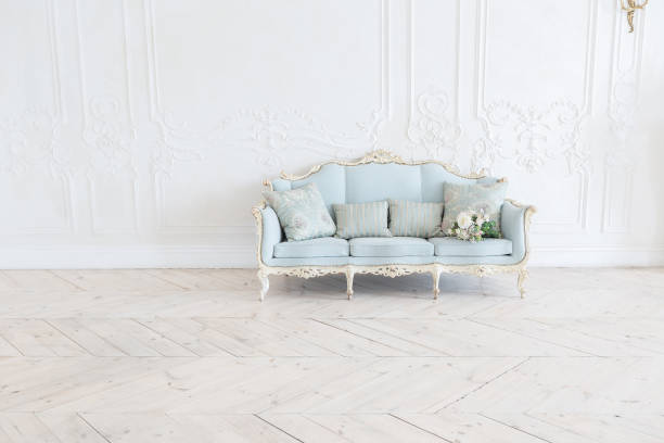 istock luxurious light interior in the Baroque style. A spacious room with a road chic beautiful furniture, a fireplace and flowers. plant stucco on the walls and light wood parquet 1298424554