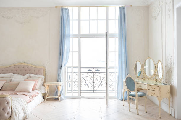 istock luxurious light interior in the Baroque style. A spacious room with a road chic beautiful furniture, a fireplace and flowers. plant stucco on the walls and light wood parquet 1298424574