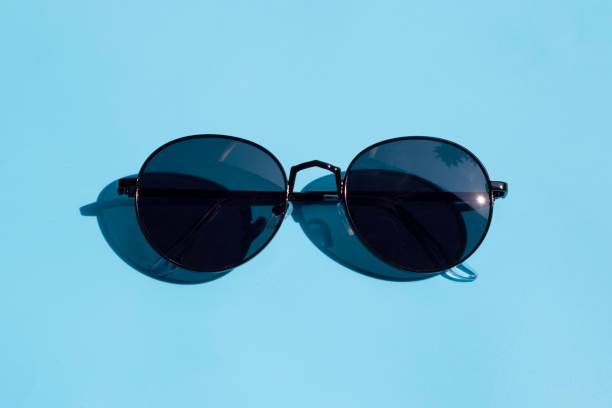 istock Sunglasses on blue background. Enjoy holiday concept. 1298424584
