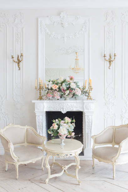 istock luxurious light interior in the Baroque style. A spacious room with a road chic beautiful furniture, a fireplace and flowers. plant stucco on the walls and light wood parquet 1298424634