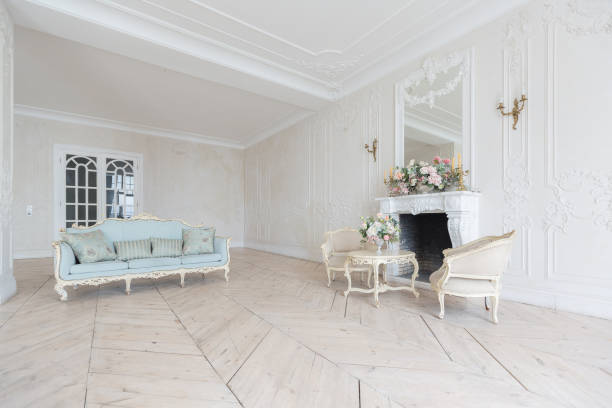 istock luxurious light interior in the Baroque style. A spacious room with a road chic beautiful furniture, a fireplace and flowers. plant stucco on the walls and light wood parquet 1298424681