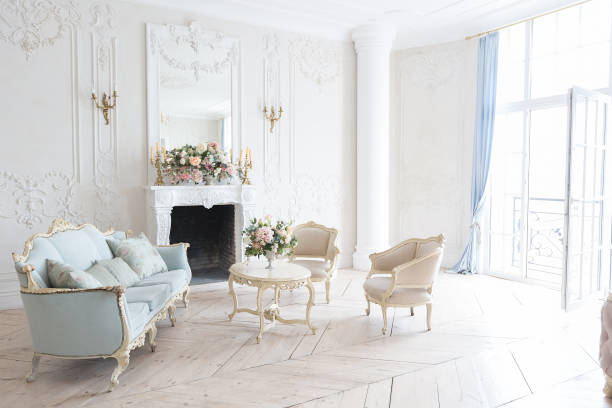 istock luxurious light interior in the Baroque style. A spacious room with a road chic beautiful furniture, a fireplace and flowers. plant stucco on the walls and light wood parquet 1298424691