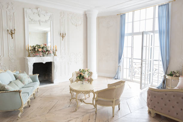 istock luxurious light interior in the Baroque style. A spacious room with a road chic beautiful furniture, a fireplace and flowers. plant stucco on the walls and light wood parquet 1298424706
