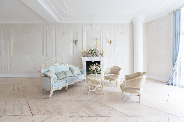istock luxurious light interior in the Baroque style. A spacious room with a road chic beautiful furniture, a fireplace and flowers. plant stucco on the walls and light wood parquet 1298424747