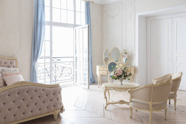 istock luxurious light interior in the Baroque style. A spacious room with a road chic beautiful furniture, a fireplace and flowers. plant stucco on the walls and light wood parquet 1298424765