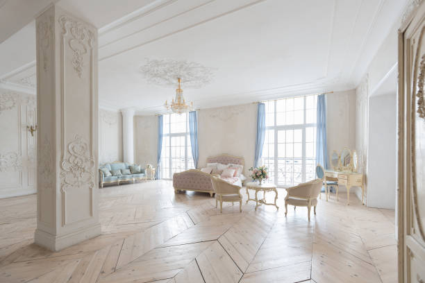 istock luxurious light interior in the Baroque style. A spacious room with a road chic beautiful furniture, a fireplace and flowers. plant stucco on the walls and light wood parquet 1298424788