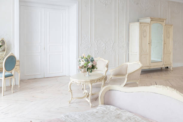 istock luxurious light interior in the Baroque style. A spacious room with a road chic beautiful furniture, a fireplace and flowers. plant stucco on the walls and light wood parquet 1298424794