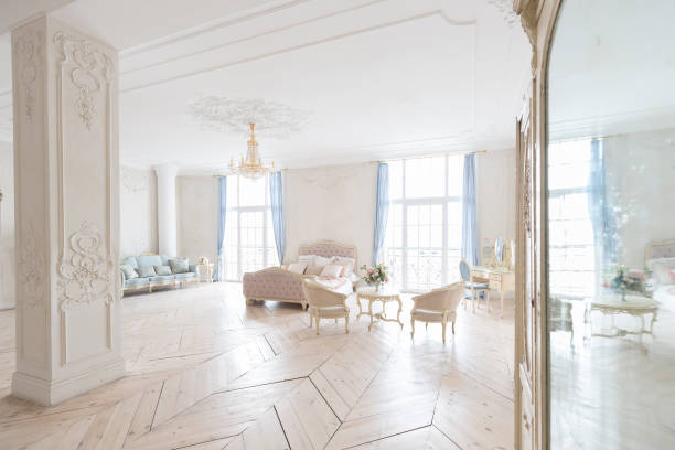 istock luxurious light interior in the Baroque style. A spacious room with a road chic beautiful furniture, a fireplace and flowers. plant stucco on the walls and light wood parquet 1298424795
