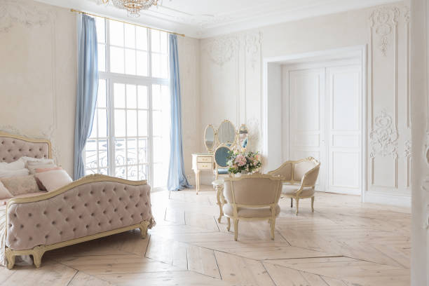 istock luxurious light interior in the Baroque style. A spacious room with a road chic beautiful furniture, a fireplace and flowers. plant stucco on the walls and light wood parquet 1298424797