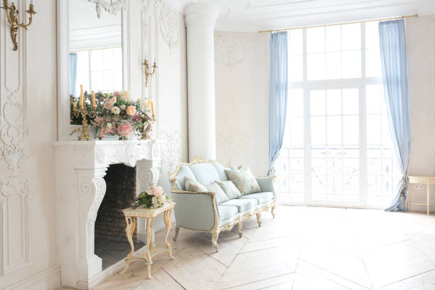 istock luxurious light interior in the Baroque style. A spacious room with a road chic beautiful furniture, a fireplace and flowers. plant stucco on the walls and light wood parquet 1298424810