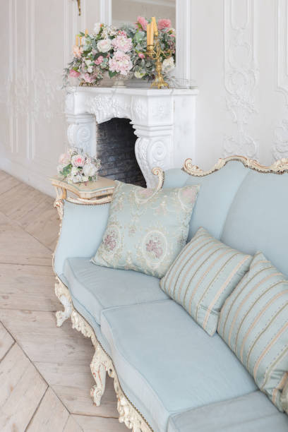 istock luxurious light interior in the Baroque style. A spacious room with a road chic beautiful furniture, a fireplace and flowers. plant stucco on the walls and light wood parquet 1298424822