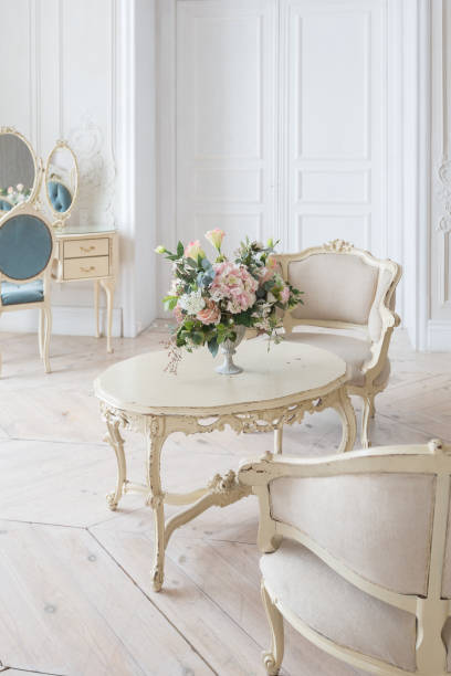 istock luxurious light interior in the Baroque style. A spacious room with a road chic beautiful furniture, a fireplace and flowers. plant stucco on the walls and light wood parquet 1298424823