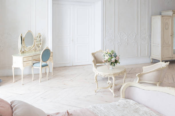 istock luxurious light interior in the Baroque style. A spacious room with a road chic beautiful furniture, a fireplace and flowers. plant stucco on the walls and light wood parquet 1298424834