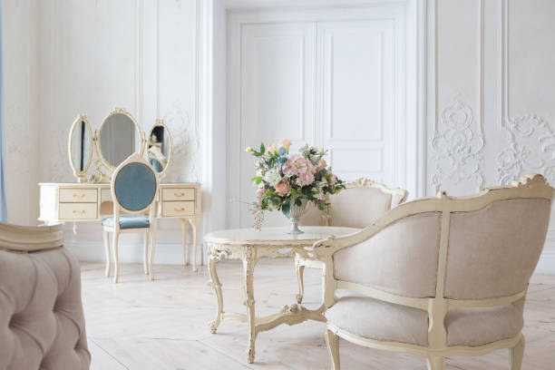 istock luxurious light interior in the Baroque style. A spacious room with a road chic beautiful furniture, a fireplace and flowers. plant stucco on the walls and light wood parquet 1298424841