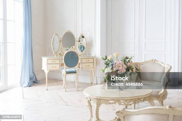 Luxurious Light Interior In The Baroque Style A Spacious Room With A Road Chic Beautiful Furniture A Fireplace And Flowers Plant Stucco On The Walls And Light Wood Parquet Stock Photo - Download Image Now