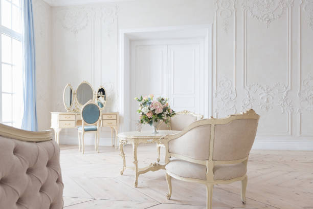 istock luxurious light interior in the Baroque style. A spacious room with a road chic beautiful furniture, a fireplace and flowers. plant stucco on the walls and light wood parquet 1298424872