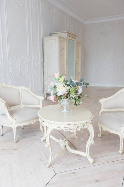 istock luxurious light interior in the Baroque style. A spacious room with a road chic beautiful furniture, a fireplace and flowers. plant stucco on the walls and light wood parquet 1298424880