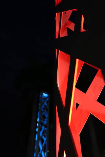 istock Patterns from metal sculptures like buildings, at night with red and blue lighting 1298424897