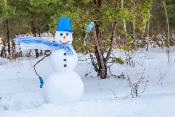 istock snowman with a scarf waving in the wind. 1298425134