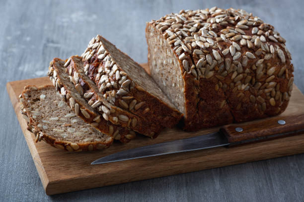 istock Sliced rye bread on cutting board. Whole grain rye bread with seeds 1298428733