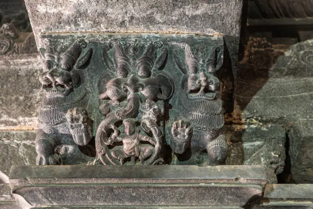Lakkundi, Karnataka, India - November 6, 2013: Kasivisvesvara Temple. Closeup of  greenish gray sculpted beam support in mandapam in front of inner sanctum. Beasty figures.