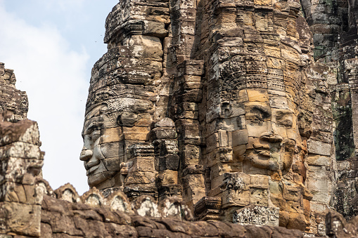Angkor, Cambodia - January 24, 2020: The Bayon a richly decorated Khmer temple at Angkor in Cambodia. Built in the late 12th or early 13th century as the state temple of the Mahayana Hindu King Jayavarman VII. The Bayon's most distinctive feature is the multitude of serene and smiling stone faces on the many towers.