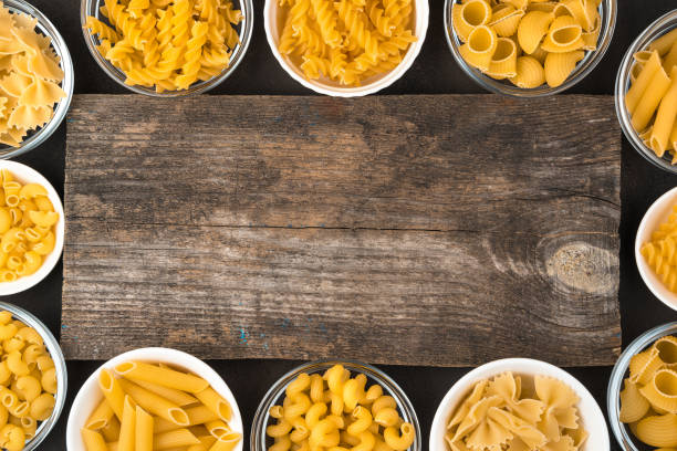 Large assortment of pasta around the wooden Board Large assortment of pasta around the wooden Board. Top view, with space to copy. Concept of products, culinary backgrounds. carbohydrate food type stock pictures, royalty-free photos & images
