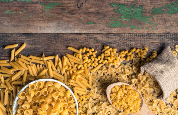 istock Pasta of different types on a wooden table. Top view with space to copy 1298432495
