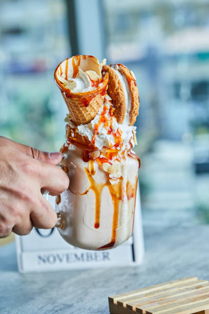 istock Hand holding a caramel ring milkshake with cookies and ice cream cone 1298433255