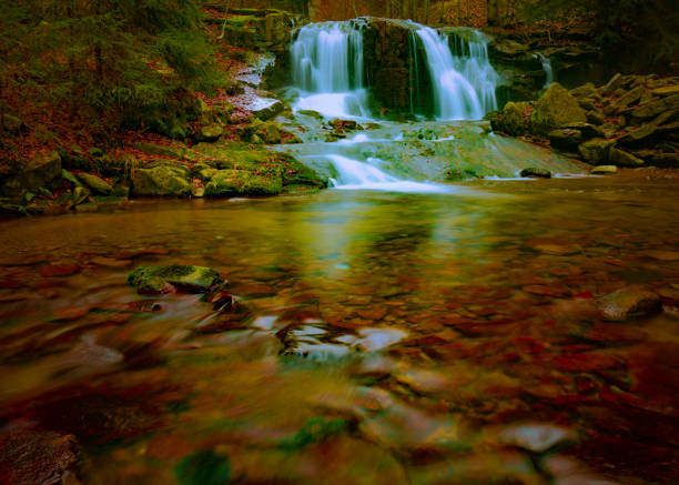 Wild brook with stones and waterfall in Jeseniky mountains, Eastern Europe, Moravia. Clean fresh cold watter, water stream. Long exposure image.