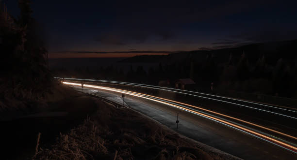 istock Car light lines on a mountain asphalt road in the evening 1298434466