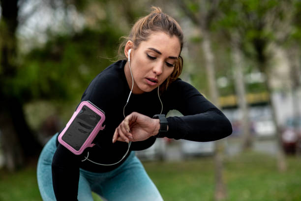 istock Young woman is resting after jogging, checking time. 1298439620