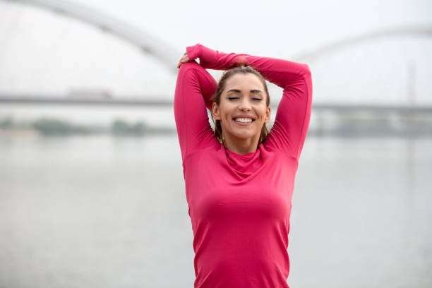 istock Brunette with ponytail is stretching, having great time outdoors. 1298439849