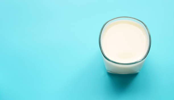 istock Glass of milk on blue background. 1298442961