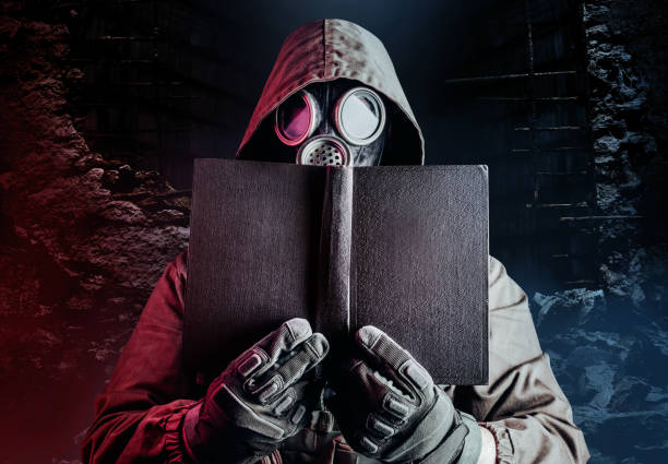 istock Stalker soldier in soviet gas mask holding old book. 1298444981