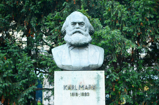 Berlin, Germany - October 16, 2013: Karl Marx statue in front of trees