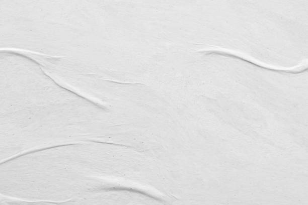 istock Blank white crumpled and creased paper poster texture background 1298447292