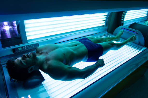 Young Muscular Man At Solarium In Beauty Salon Young Muscular Man At Solarium In Beauty Salon tanning bed stock pictures, royalty-free photos & images