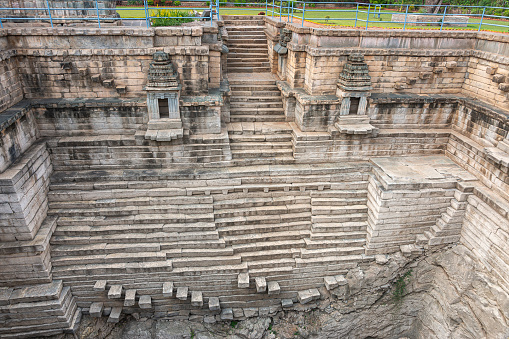 Lakkundi, Karnataka, India - November 6, 2013: Musakeena Bhavi step tank. View on on entire gray stone stairway side starting on ground level into the deep dry end.
